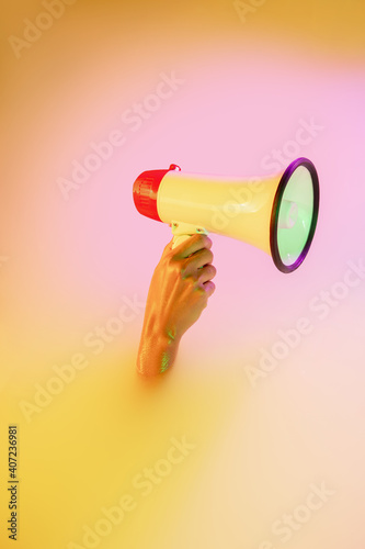 News, shouting, anouncement. Close up female hand gesturing from the milk bath with soft white glowing in neon light. Copyspace for advertising. Holding megaphone, rupor. Modern neoned colors. photo