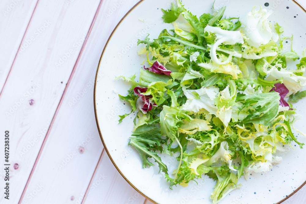 White ceramic plate with fresh salad on wooden background White ceramic plate with fresh salad on wooden background