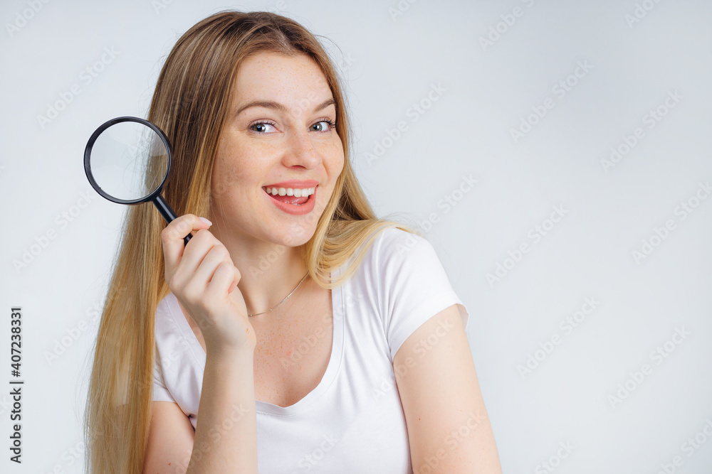 Happy smiling female holding magnifying glass, isolated on white background Happy smiling female holding magnifying glass, isolated on white background