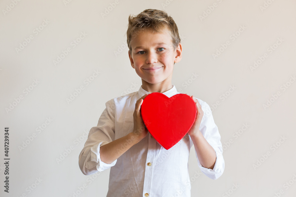 Cute boy holding in hands heart shaped gift box for Valentines day Cute boy holding in hands heart shaped gift box for Valentines day