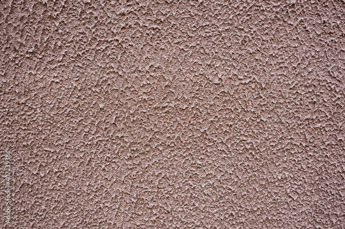 Close-up image of rough textured wall surface with plaster splashes pattern