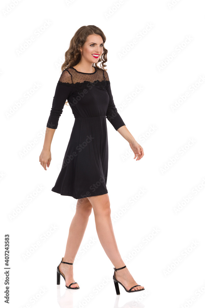 Smiling Woman Is Walking In Elegant Black Dress And High Heels. Smiling Woman Is Walking In Elegant Black Dress And High Heels.