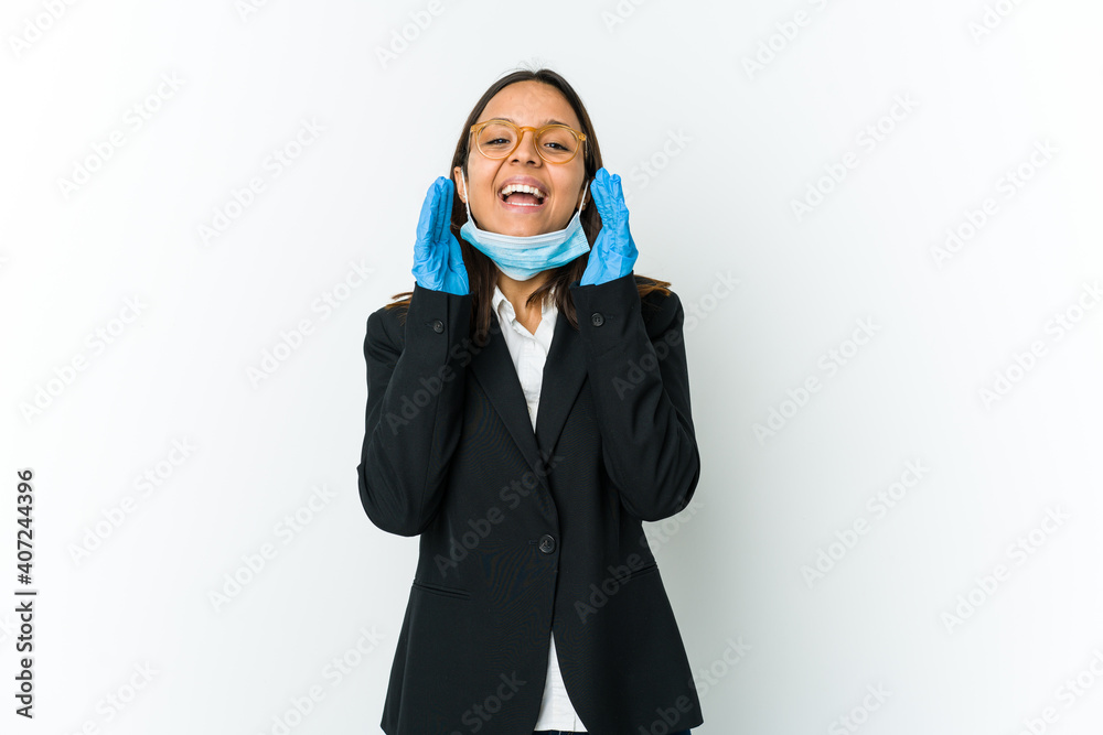 Young business latin woman wearing a mask to protect from covid isolated on white background shouting excited to front. Young business latin woman wearing a mask to protect from covid isolated on white background shouting excited to front.