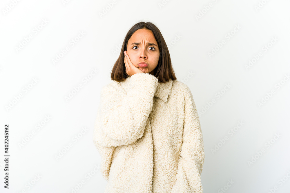 Young mixed race woman blows cheeks, has tired expression. Facial expression concept. Young mixed race woman blows cheeks, has tired expression. Facial expression concept.