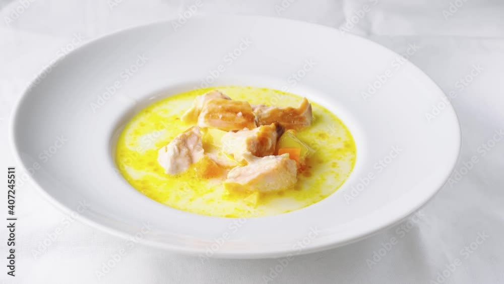 Pouring healthy salmon cream soup into white plate Pouring healthy salmon cream soup into white plate
