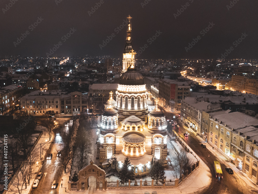 Holy Annunciation Cathedral illuminated in winter snowy evening lights. Aerial view Kharkiv city orthodox church in downtown, Ukraine. Front view from air