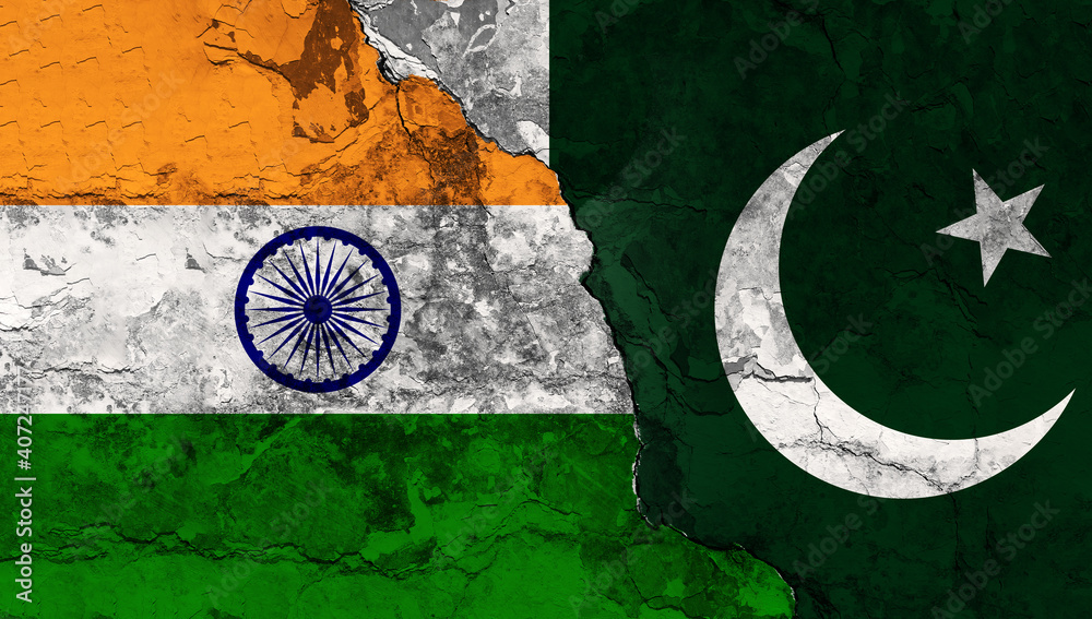 Concept of a Conflict between India and Pakistan with painted flags on a wall with a crack