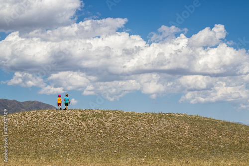 Two children stand on a hill in the middle of the steppe in Kazakhstan
