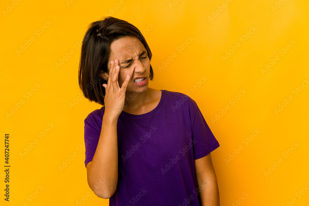 Young hispanic woman isolated on yellow touching temples and having headache. Young hispanic woman isolated on yellow touching temples and having headache.