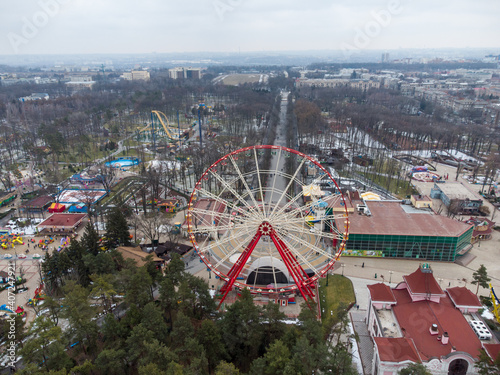Ferris wheel spinning and Christmas New year tree aerial day view in Kharkiv city center Park of Maxim Gorky. Seasonal holidays traditional fair recreation © Kathrine Andi