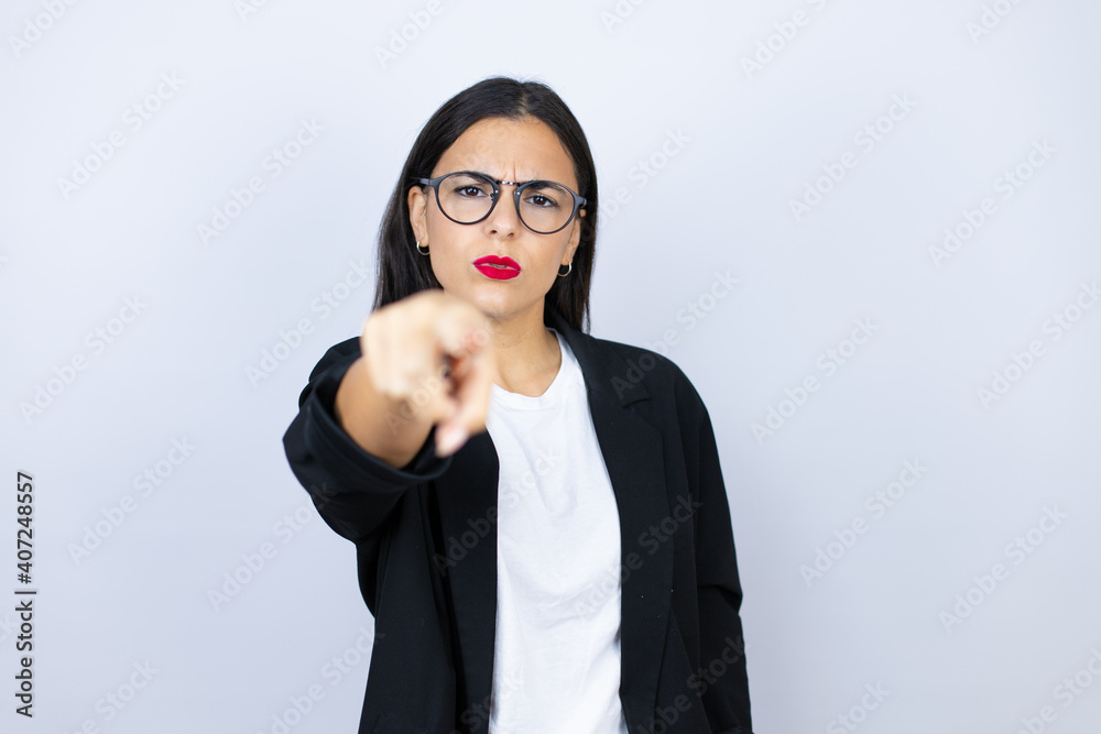 Beautiful business woman pointing with finger to the camera and to you, confident gesture looking serious Beautiful business woman pointing with finger to the camera and to you, confident gesture looking serious