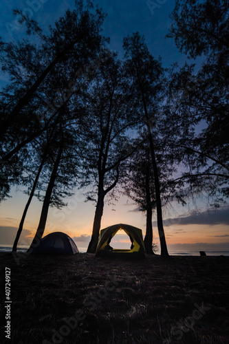 silhouette camping tent on beach with sunrise and sea background