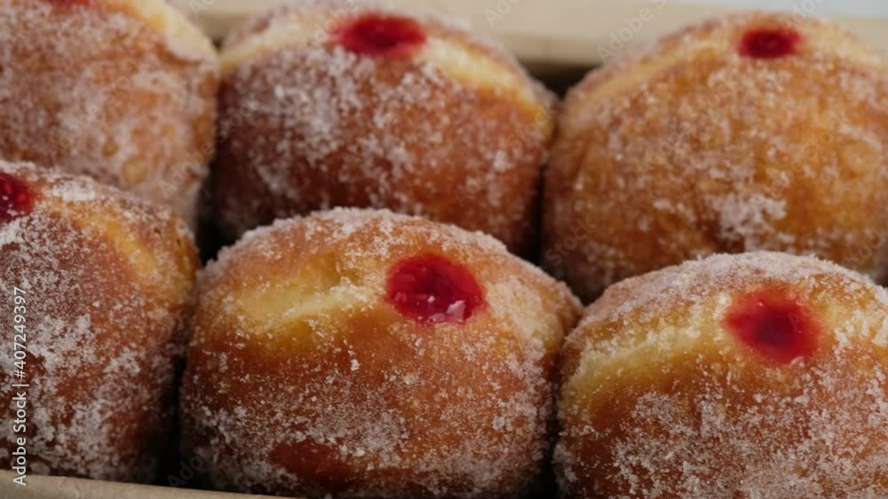 Close-up camera movement. Berliners. Donuts with raspberry jam lie on a serving tray on a white plate, a donut with a flowing filling. Delicious sweet donuts. Making donuts with jam. Close-up camera movement. Berliners. Donuts with raspberry jam lie on a serving tray on a white plate, a donut with a flowing filling. Delicious sweet donuts. Making donuts with jam.