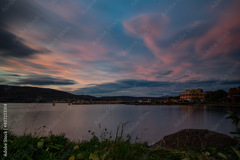 Shore of Tromsø during sunset with mountains in the background