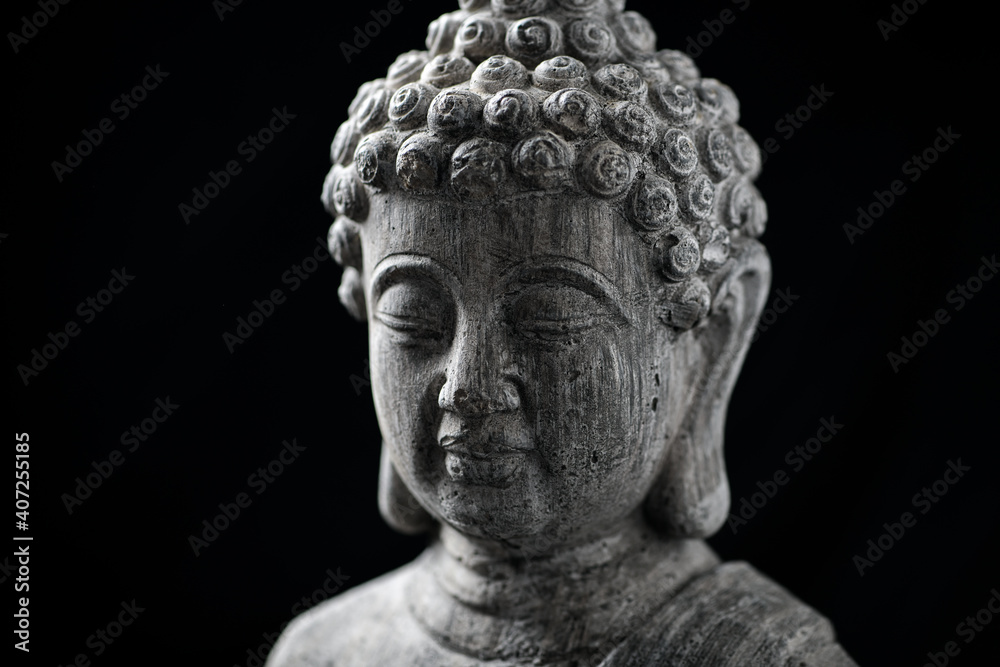 Meditating Buddha Statue isolated on black background. Copy space.	
