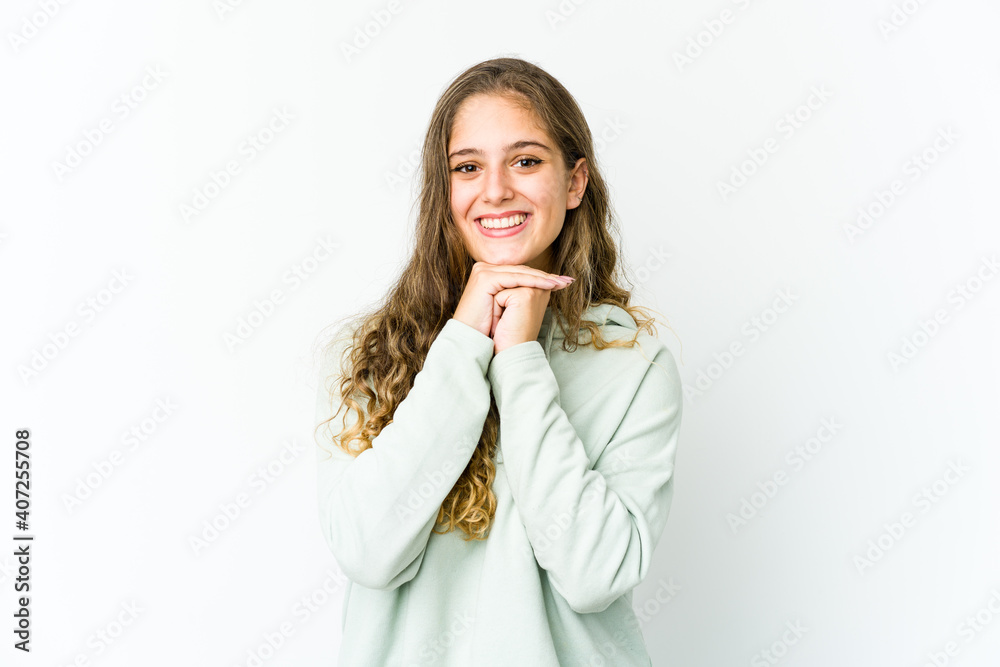 Young caucasian woman keeps hands under chin, is looking happily aside. Young caucasian woman keeps hands under chin, is looking happily aside.
