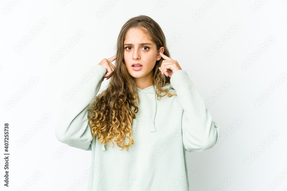 Young caucasian woman covering ears with fingers, stressed and desperate by a loudly ambient. Young caucasian woman covering ears with fingers, stressed and desperate by a loudly ambient.