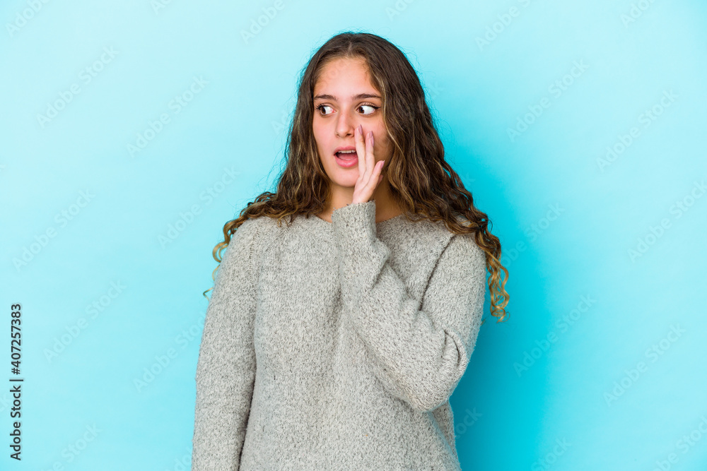 Fototapeta premium Young caucasian curly hair woman isolated is saying a secret hot braking news and looking aside