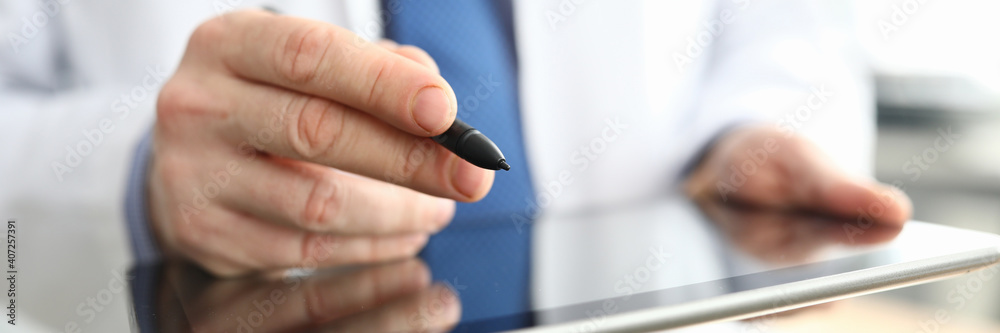 The doctor is holding a tablet and pen. Platform for an online consultation with doctors during a pandemic The doctor is holding a tablet and pen. Platform for an online consultation with doctors during a pandemic