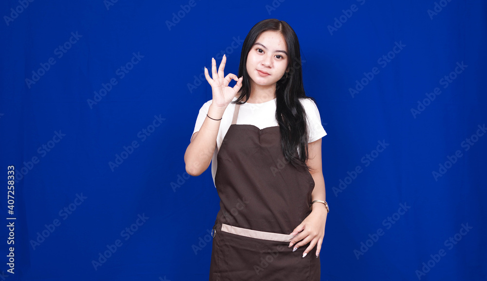 Fototapeta premium asian woman shopkeeper OK gesture isolated blue background