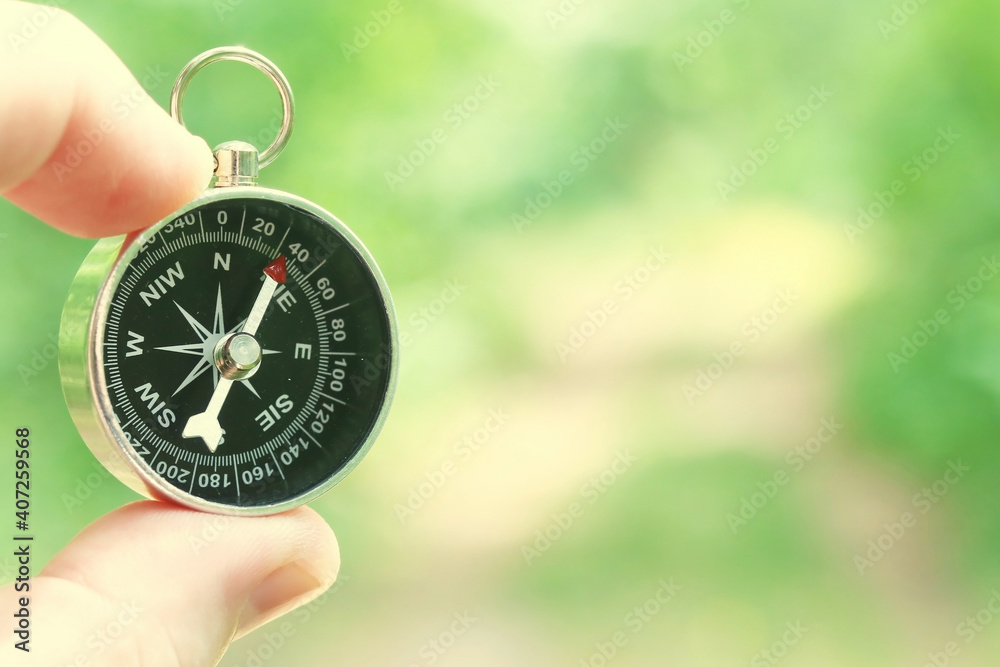 Old classic navigation compass in hand on natural background as symbol of tourism with compass, travel with compass and outdoor activities with compass Old classic navigation compass in hand on natural background as symbol of tourism with compass, travel with compass and outdoor activities with compass