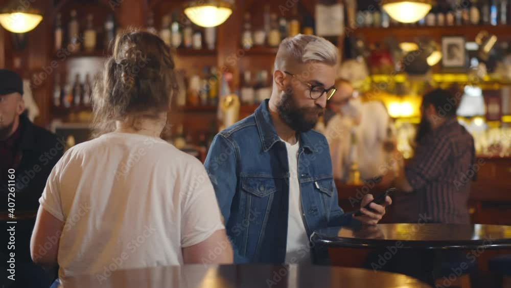 Waitress wearing safety mask and gloves taking empty glasses from tables in modern bar Waitress wearing safety mask and gloves taking empty glasses from tables in modern bar