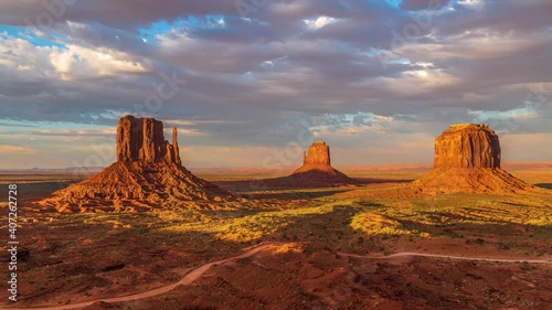 Beautiful orange and pink sunset timelapse with unique geological rock formations and clouds flowing in Monument Valley, Arizona United States