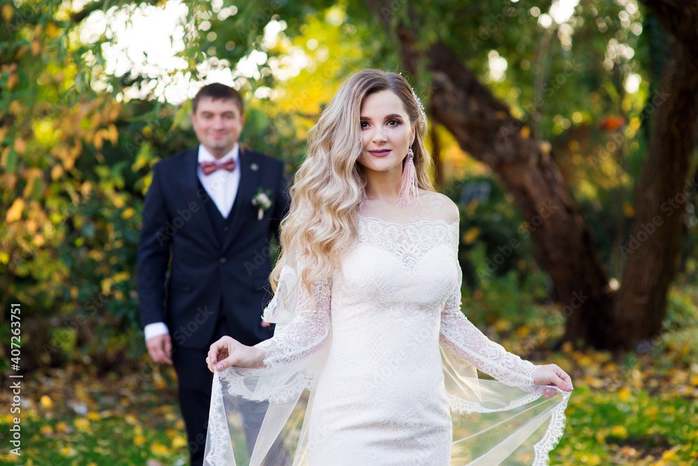 Bride with veil and groom in the garden Bride with veil and groom in the garden
