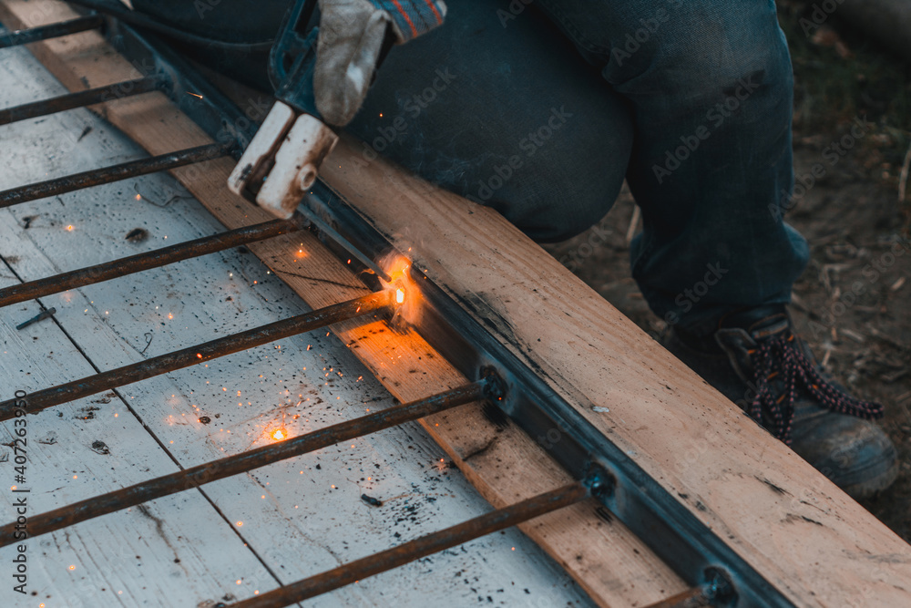 A man welds a metal frame to build an aviary, welding metal close up. A man welds a metal frame to build an aviary, welding metal close up.