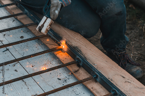 A man welds a metal frame to build an aviary, welding metal close up.