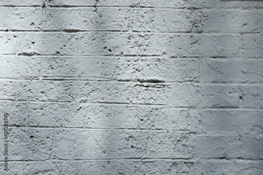 Obraz premium Rough white painted brick wall with shadows.
