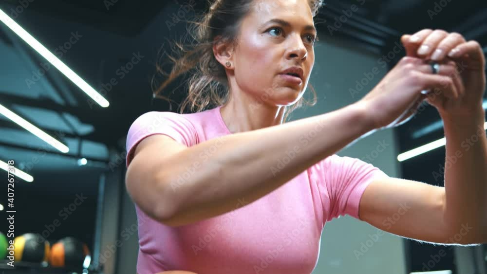 Female athlete is performing box jumps at gym. Young crossfit athlete doing box jump exercise at gym. Fit young woman jumping at crossfit style at the wooden box at gym.Woman jumping onto the box Female athlete is performing box jumps at gym. Young crossfit athlete doing box jump exercise at gym. Fit young woman jumping at crossfit style at the wooden box at gym.Woman jumping onto the box