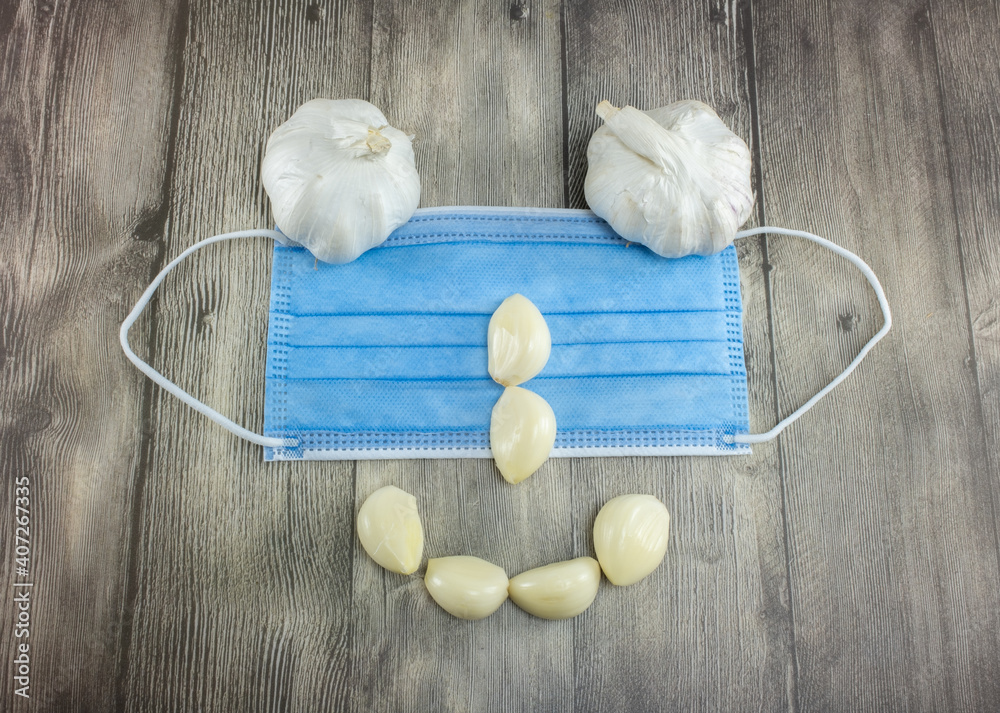 Fototapeta premium Human face of garlic and a hygienic mask
