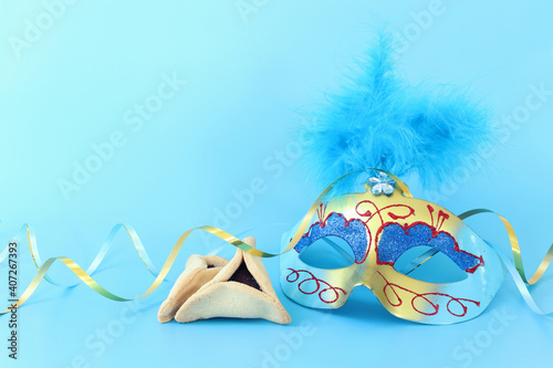 Purim celebration concept (jewish carnival holiday) over pastel blue background