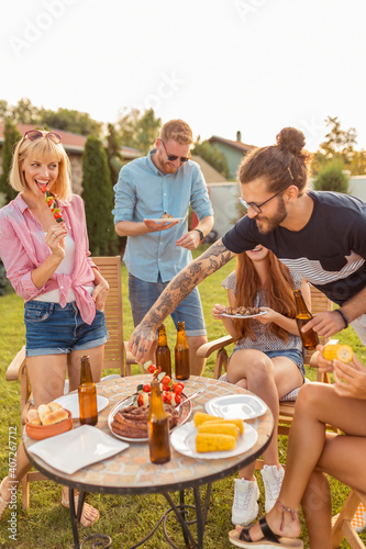 Group of young friends having a backyard barbecue party