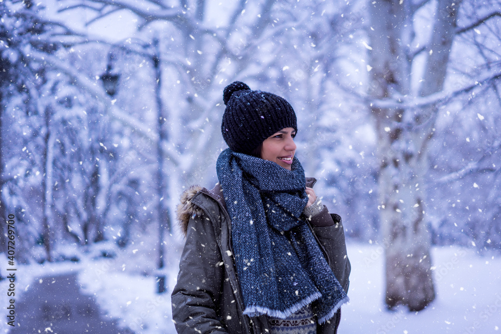 Beautiful happy female in the winter walk outdoors with a lot of snow