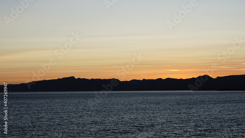 sea side mountain silhouette at sunset