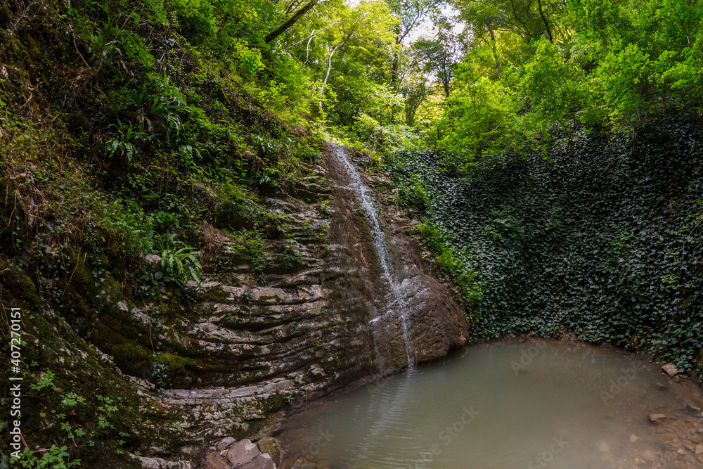 Landscape with a waterfall and a small lake Landscape with a waterfall and a small lake