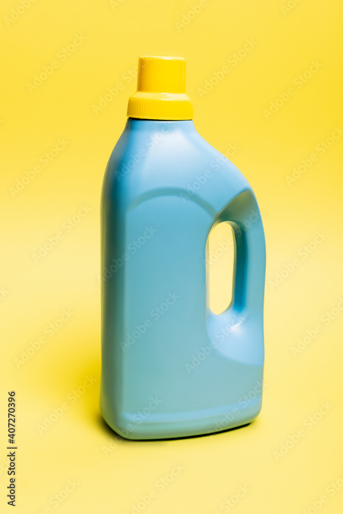 Blue bottle of detergent on yellow background Blue bottle of detergent on yellow background