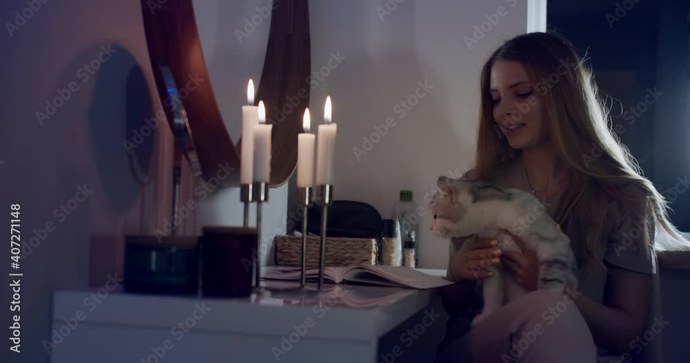 A girl in the bedroom by candlelight with a cat in her arms. Slow motion 4k. A girl in the bedroom by candlelight with a cat in her arms. Slow motion 4k.