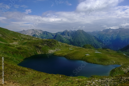 gorgeous blue mountain lake in green hills with little ponds © thomaseder