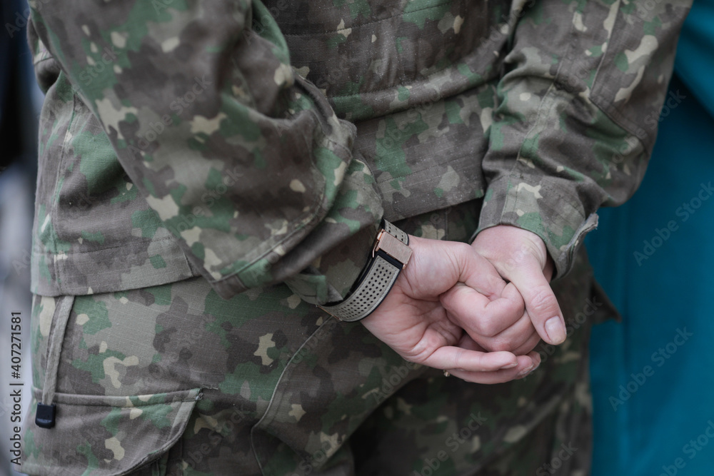 Shallow depth of field (selective focus) image with the hands of a female soldier.