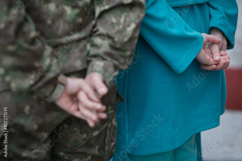 Shallow depth of field (selective focus) image with the hands of a medic and the ones of a military medic.