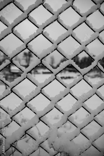Snow lying on a chain link fence, winter background