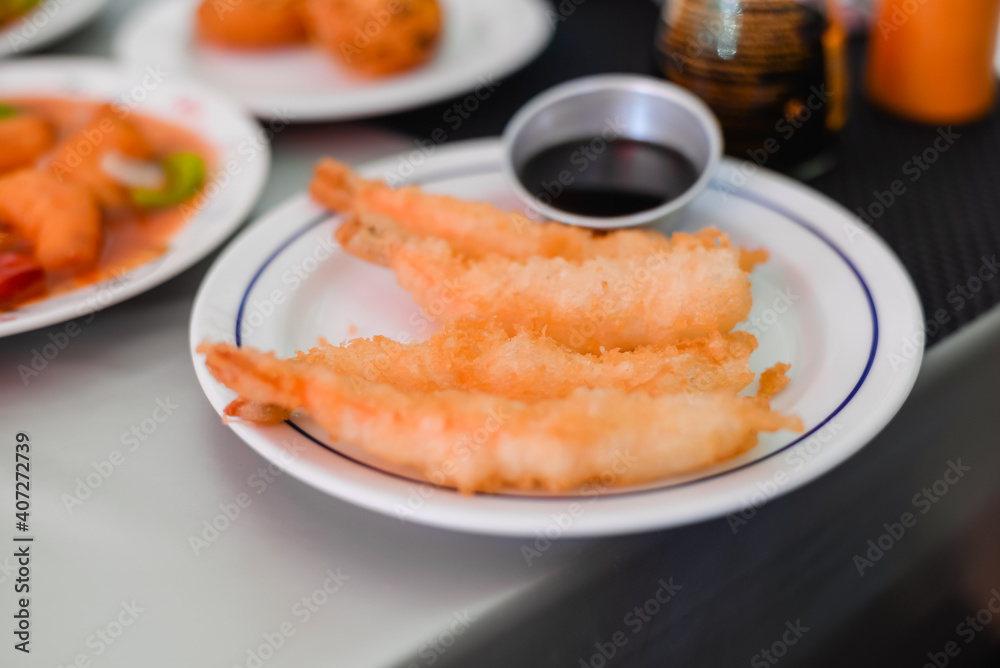 Kid using chopsticks to pick up shrimps isolated on a white background. Healthy eating lifestyle concept. Kid using chopsticks to pick up shrimps isolated on a white background. Healthy eating lifestyle concept.