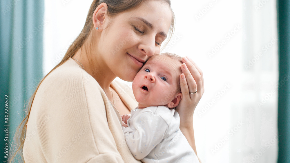 Closeup portrait of happy smiling mother holding and looking on her newborn baby boy. Concept of family happiness and loving parents with little children Closeup portrait of happy smiling mother holding and looking on her newborn baby boy. Concept of family happiness and loving parents with little children