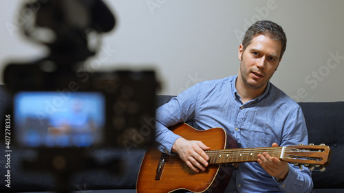 Man with spanish guitar in front of the video camera.