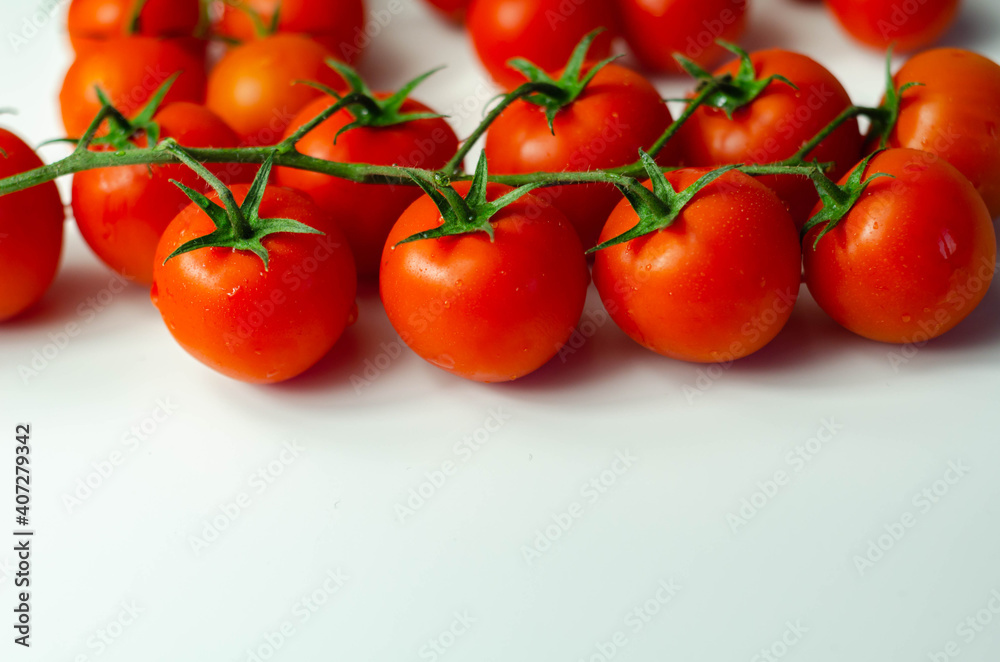 Covered with drops of water, fresh tomatoes with sprigs on white background Covered with drops of water, fresh tomatoes with sprigs on white background