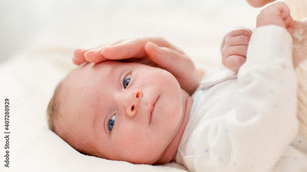 Closeup shot of happy smiling mother and adorable newborn baby boy lyin in crib against big window. Concept of family happiness and loving parents with little children Closeup shot of happy smiling mother and adorable newborn baby boy lyin in crib against big window. Concept of family happiness and loving parents with little children