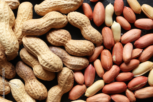 Photograph of a handful of peanuts whole and peeled for food background